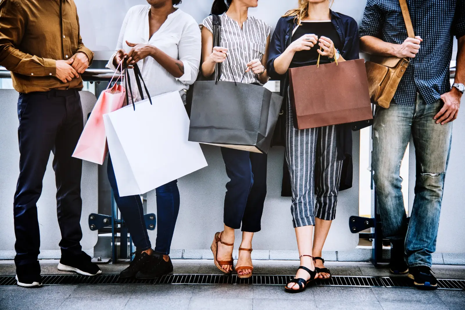 men and girls are standing with shoping bags